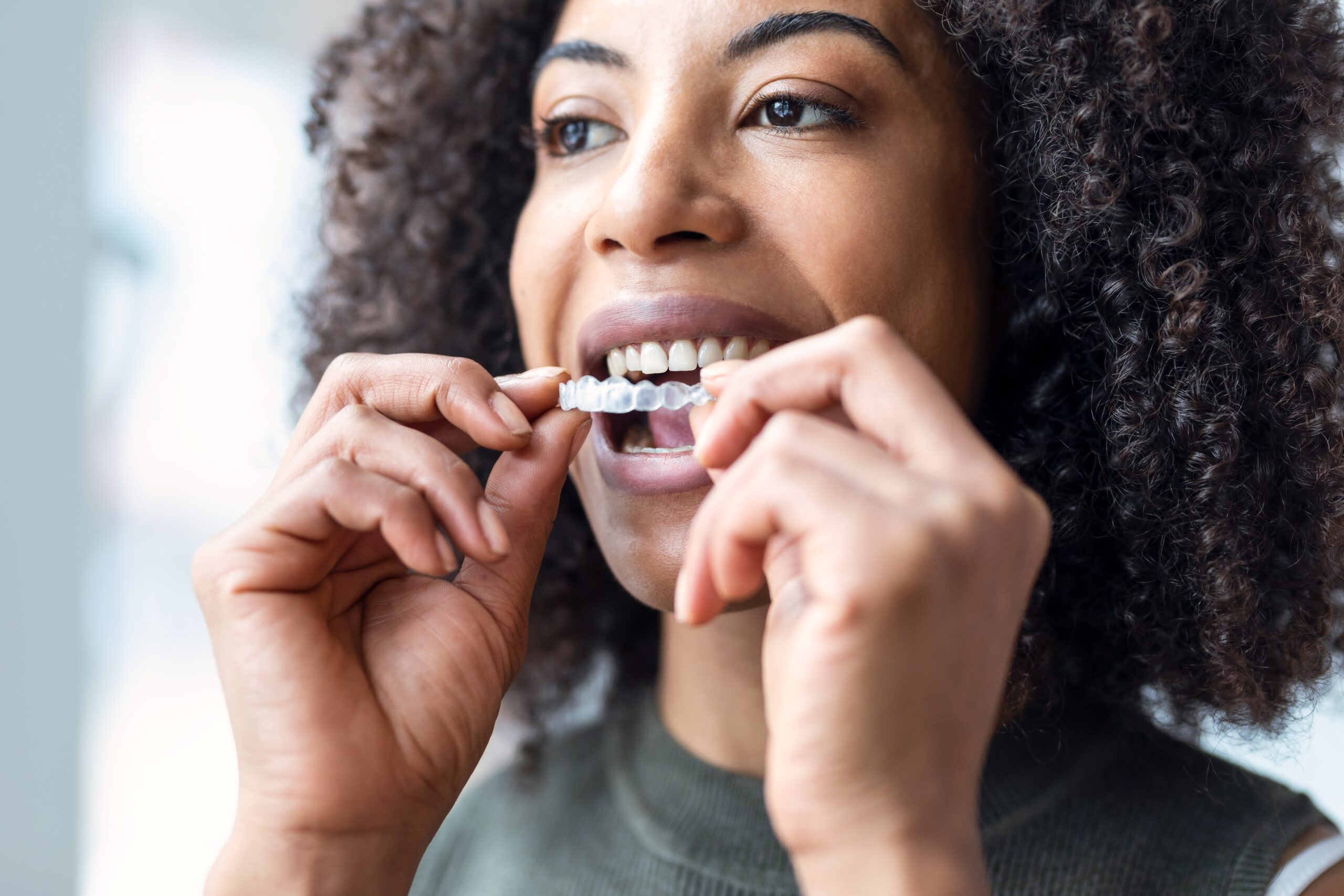 young woman putting in her clear aligner therapy